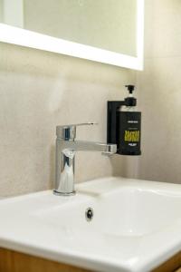a bathroom sink with a faucet and a mirror at Vista Point Suites in Marsalforn +45 photos