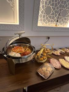 a table with a pan of food on a table at GUZAL Hotel PREMIUM in Bukhara