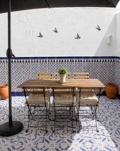 a table with chairs and an umbrella in a room at Casa Paco & Carmela in Algodonales
