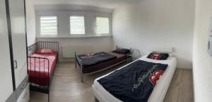 a bedroom with two beds and a window at Ferienwohnung Sauerländer in Plettenberg