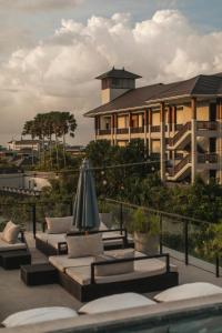 a building with tables and an umbrella in front of it at Surf Motel Canggu in Canggu