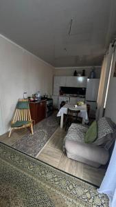 a living room with a couch and a table at Sarytam in Bosteri