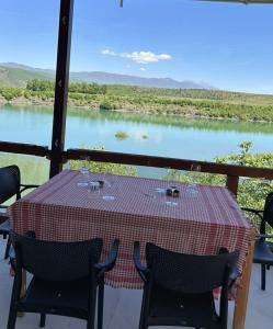a table with chairs and a view of a river at SuperPanorama GuestHouse in Kukës