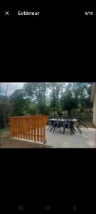 a group of picnic tables and a wooden fence at Charmante maison in Sussac