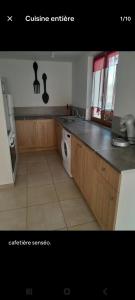 a kitchen with a sink and a washing machine at Charmante maison in Sussac