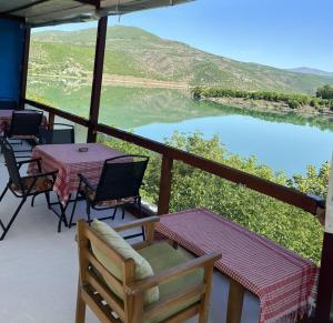 a balcony with tables and chairs and a view of a lake at SuperPanorama GuestHouse in Kukës