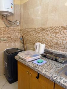 a kitchen with a counter top with a suitcase at saidia 700 m de la plage in Saïdia +31 photos