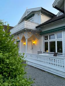 a white house with a porch and windows at Thorsagården in Listerby