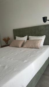 a large bed with white sheets and pillows at Afife Beach Apartment in Afife