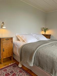 a bedroom with a bed and a night stand and a table at Thorsagården in Listerby