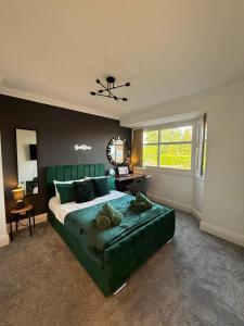 a bedroom with a large green bed and a window at Emerald Manor - Free Parking - Free Wifi in Solihull
