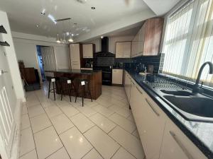 a large kitchen with a sink and a counter at Emerald Manor - Free Parking - Free Wifi in Solihull +5 photos