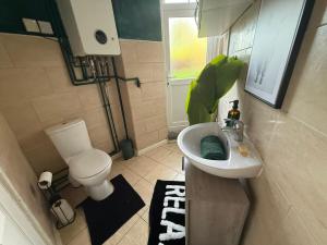 a small bathroom with a toilet and a sink at Emerald Manor - Free Parking - Free Wifi in Solihull