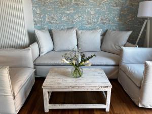 a living room with a couch and a table with flowers at Platessa in Portovenere +33 photos