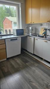 a kitchen with white cabinets and a large window at Jämsän Kulma in Halli +19 photos