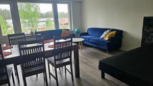a living room with a blue couch and a table and chairs at Jämsän Kulma in Halli