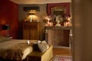 a bedroom with a fireplace and a bed and a mirror at B&B Alexandre in Herzele