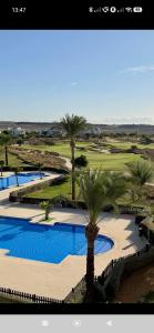 a view of a golf course with two pools and palm trees at Casa Ma-Thé, l'art de vivre in Sucina