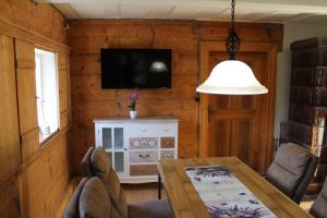 a dining room with a table and a tv at Ferienhaus Elsa mit Sauna und Whirlpool in Großschönau