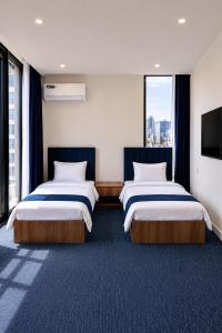 a hotel room with two beds and a flat screen tv at View Lounge Hotel in As Sulaymānīyah