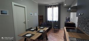 a dining room with a table and chairs and a kitchen at Neapolis casa vacanza in Terralba +2 photos