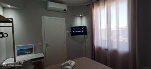 a room with a window and a door with a television at Neapolis casa vacanza in Terralba
