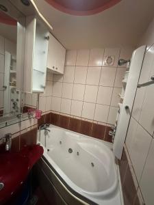 a bathroom with a tub and a red stool at Apartament MARY in Constanţa