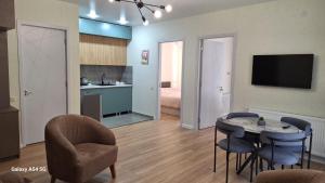 a living room with a table and chairs and a kitchen at Nerse's Apartment in Borjomi