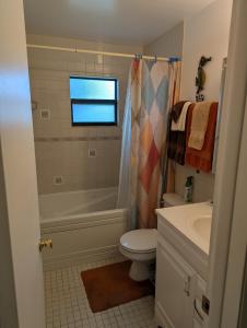 a bathroom with a tub and a toilet and a sink at Small Town Florida in Jensen Beach