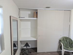 a room with white walls and a mirror and a chair at Small Town Florida in Jensen Beach