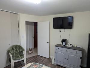a bedroom with a tv on the wall and a chair at Small Town Florida in Jensen Beach