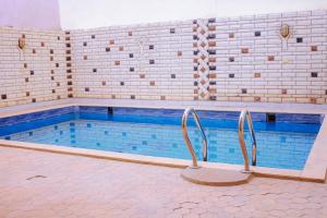 a swimming pool with two chairs in front of it at Villa Abo Ishak in Luxor