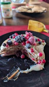 a piece of cake with berries on a black plate at La demeure de vos désirs in Pressac