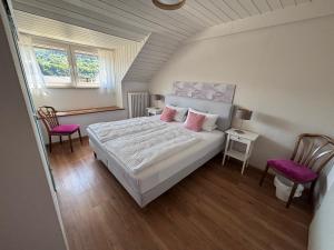 a bedroom with a bed with two pink pillows at Gästehaus Am Rebenhang in Mehring