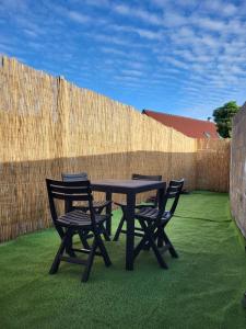 a picnic table with two chairs and a fence at petite maison avec jardin in Berck-sur-Mer