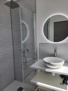 a white bathroom with a sink and a shower at petite maison avec jardin in Berck-sur-Mer +5 photos