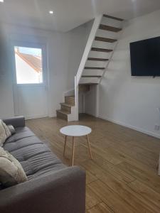 a living room with a couch and a table at petite maison avec jardin in Berck-sur-Mer