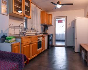 a kitchen with wooden cabinets and a white refrigerator at CasaMarinela in Orşova