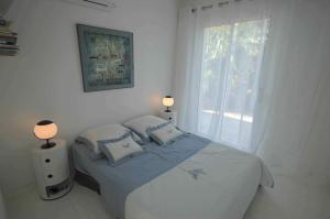 a bedroom with a bed with two pillows and a window at Sur la plage in Lumio