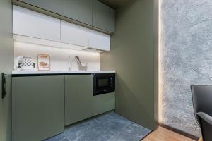 a kitchen with a sink and a microwave at Deribasivska 20 Nice Apartment in Odesa