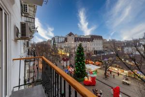a balcony with a christmas tree on a city street at Deribasivska 20 Nice Apartment in Odesa