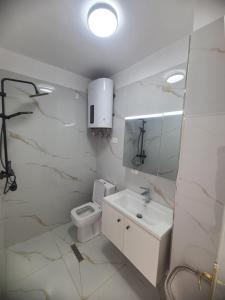 a white bathroom with a toilet and a sink at SeaView 7 Floor -No Elevater in Durrës +12 photos