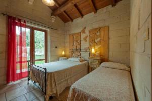 a bedroom with two beds and a window at Masseria Copertini in Vernole