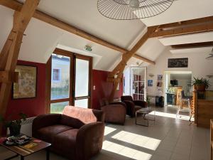 a living room with leather furniture and wooden beams at Le Relais Côtier in Sauzon