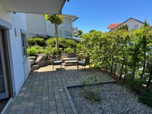 a patio with a table and chairs in a yard at Modernes Apartment zum wohlfühlen und entspannen, max 4 Personen, Top Ausstattung in Trunkelsberg