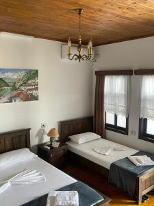 a bedroom with two beds and a chandelier at Guest House Genti in Berat