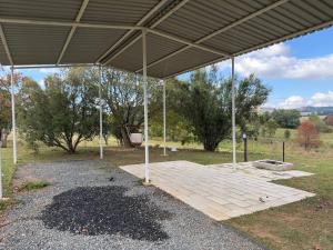 a large pavilion with a lot of gravel and trees at Tranquility Campsite in Winterton