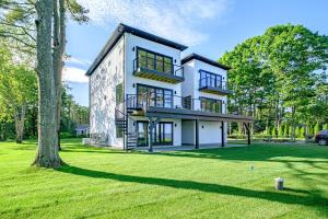 a large white house with a tree in the yard at Modern Ocean Front Home 4 bed, 5 bath Freeport in Freeport
