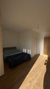 a bedroom with a bed and a wooden floor at Appartemani EMIE in Donji Štoj
