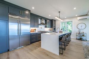 a kitchen with blue cabinets and a large refrigerator at Modern Ocean Front Home 4 bed, 5 bath Freeport in Freeport